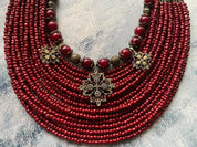 Handmade red Ukrainian multi-row necklace with antique-style glass beads and intricate metal fittings.