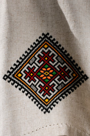 Close-up of Ukrainian embroidered tablecloth with traditional ethnic design in vibrant colors on linen fabric.