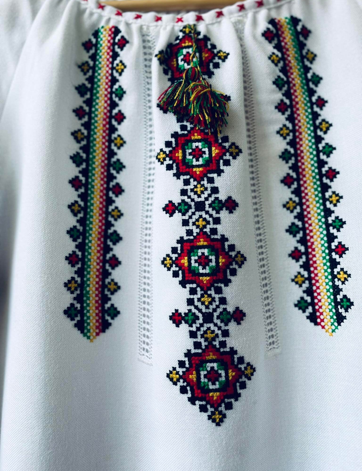 Handmade Ukrainian Vyshyvanka blouse with vibrant cross-stitch embroidery, showcasing traditional folklore and boho style.