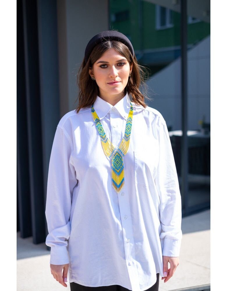 Woman wearing 2025 handmade Ukrainian gerdan necklace in blue and yellow, showcasing beaded folk jewelry style.