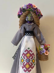 Handmade Bereginya Motanka doll in traditional Ukrainian attire with floral crown and embroidered apron on wooden stand, home protector.