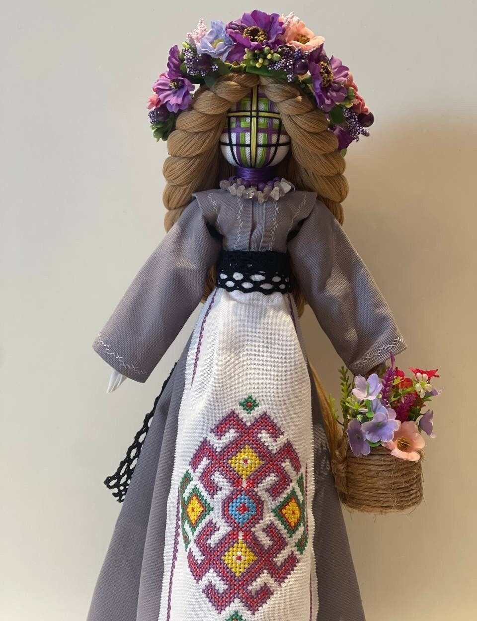 Handmade Bereginya Motanka Doll on Wooden Stand, adorned with flowers, symbol of Ukrainian protection and prosperity.