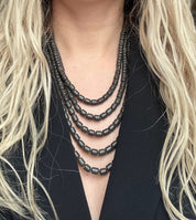 Black ceramic Ukrainian necklace with Hutsul ethnic design, worn by model, showcasing elegant handmade beads.