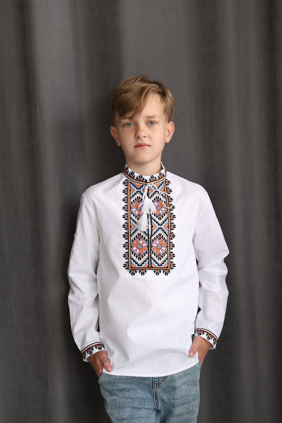 Boy wearing a handmade boys’ cotton Vyshyvanka, traditional Ukrainian embroidered shirt with colorful cross-stitch, for children.