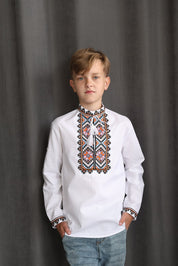 Boy wearing a handmade boys’ cotton Vyshyvanka, traditional Ukrainian embroidered shirt with colorful cross-stitch, for children.