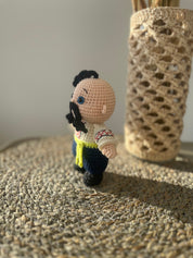 Handmade crochet Cossack doll, Ukrainian folk art, ethnic home decor on woven surface.