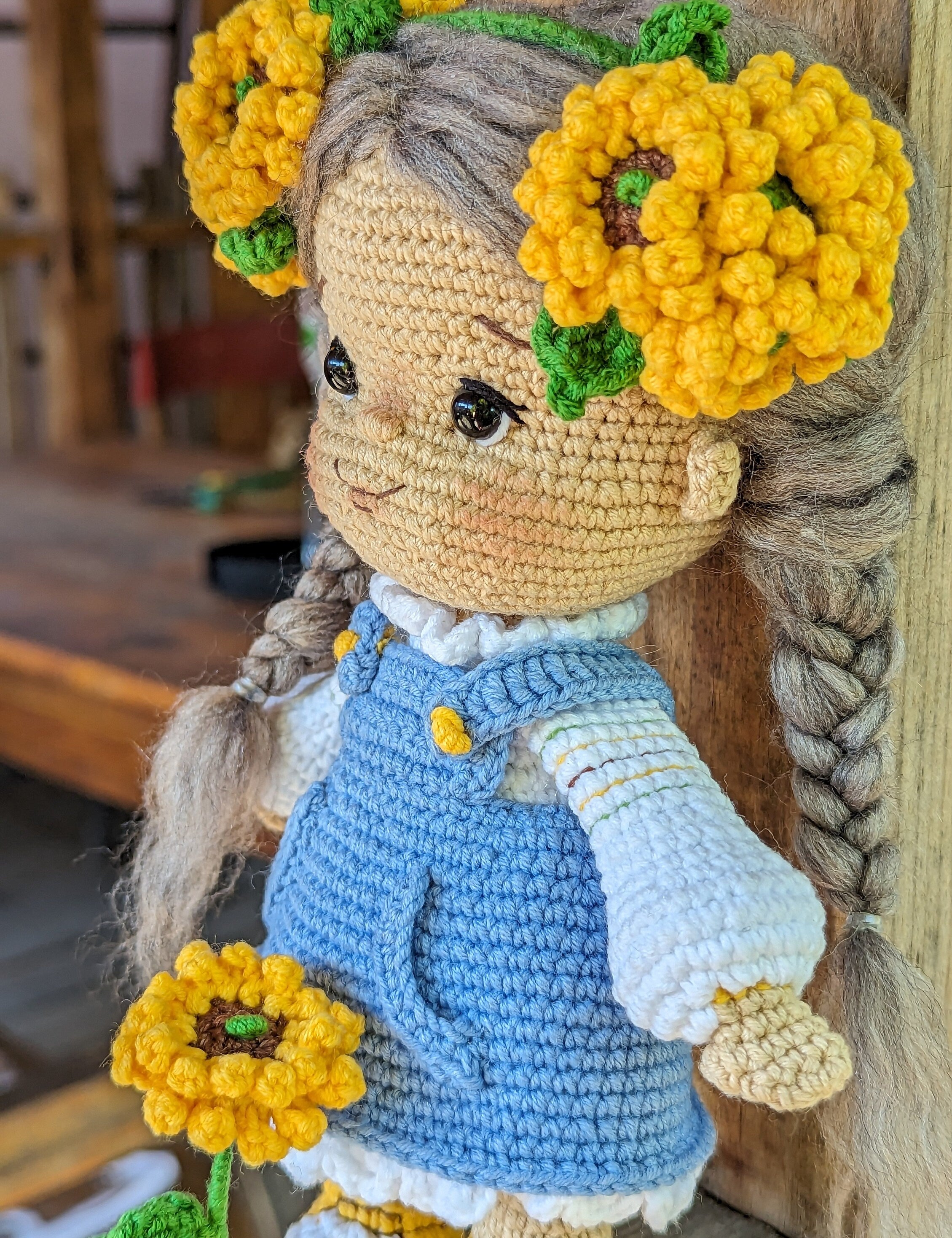 Handmade crochet Ukrainian doll with yellow flower adornments and blue dress, perfect cultural gift or nursery decor.