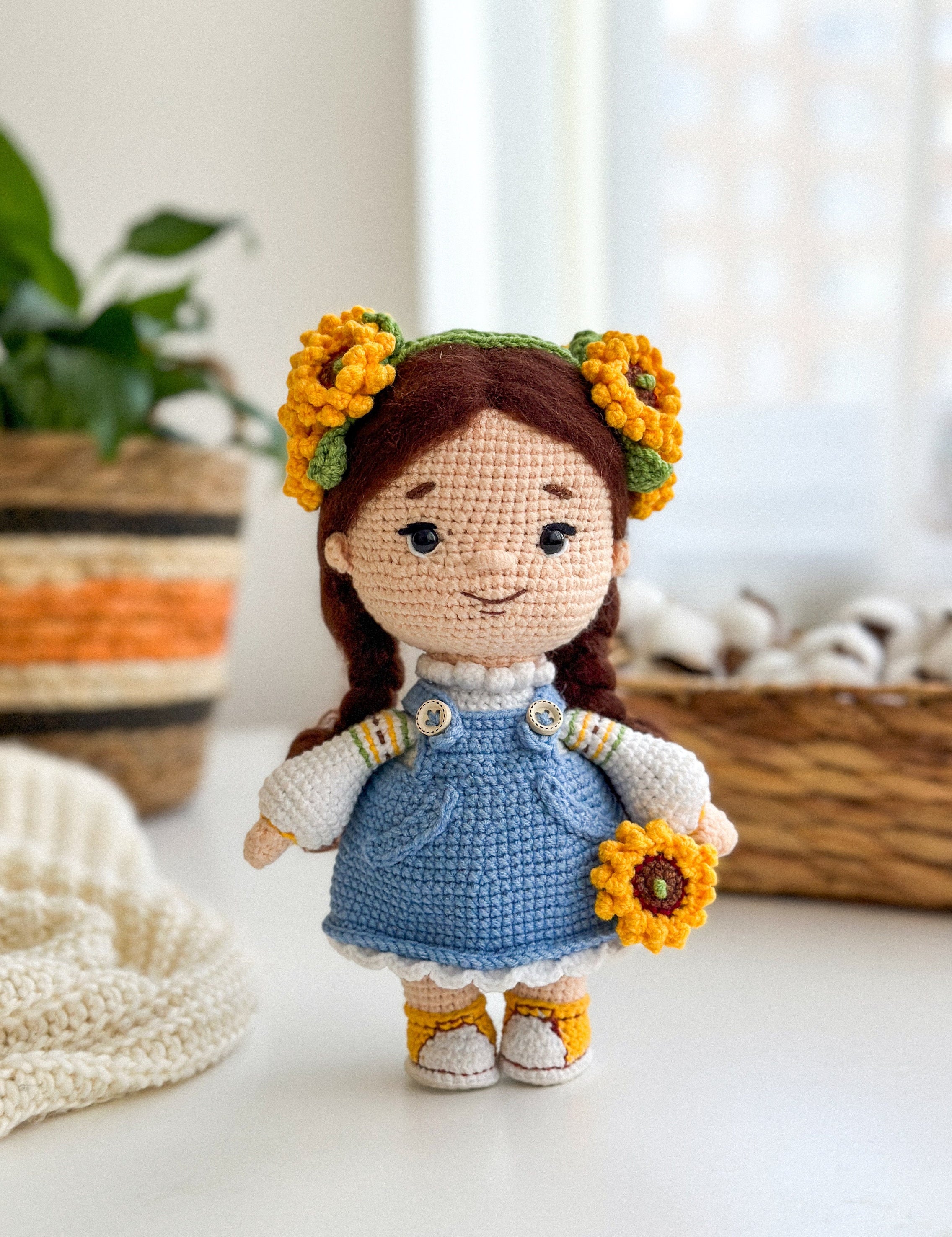 Handmade knitted doll with sunflower headband, wearing a blue dress, symbolizing Ukrainian culture. Perfect keepsake gift.