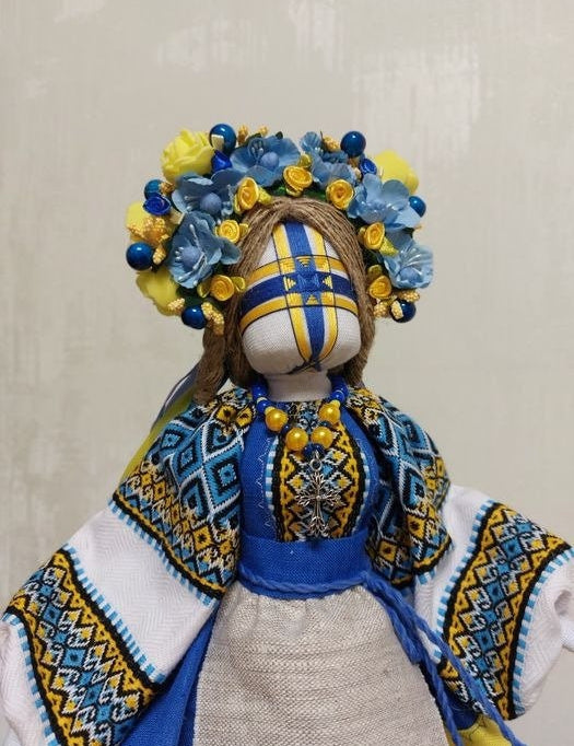 Handmade Ukrainian Motanka Doll with blue and yellow embroidery, floral headdress, symbolizing protection and Ukrainian heritage.