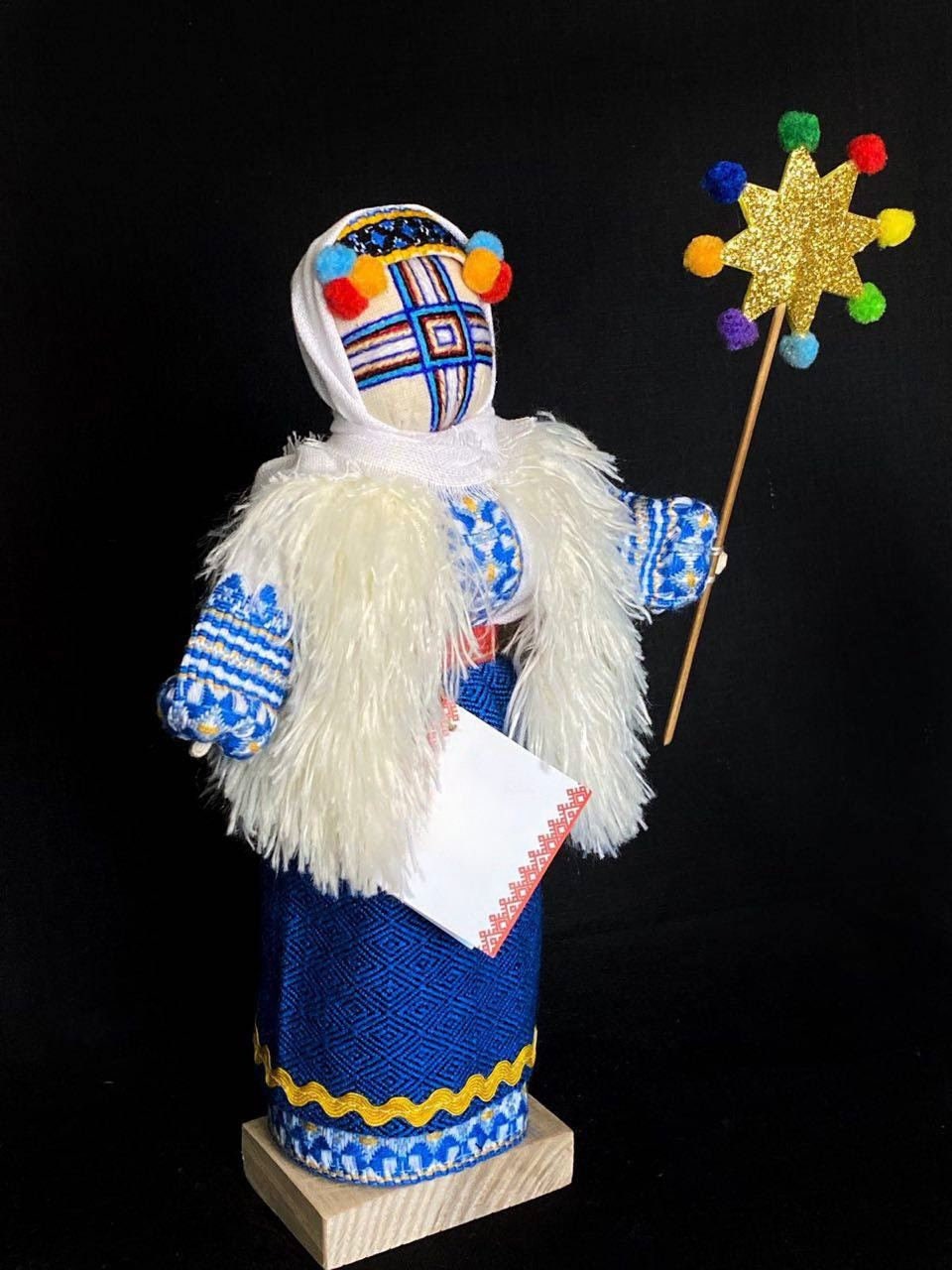 Handmade Motanka doll on wooden stand, symbolizing Ukrainian heritage and protection, adorned in festive attire.
