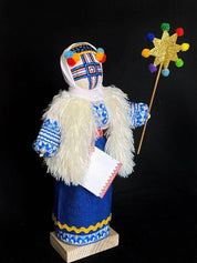 Handmade Motanka doll on wooden stand, symbolizing Ukrainian heritage and protection, adorned in festive attire.