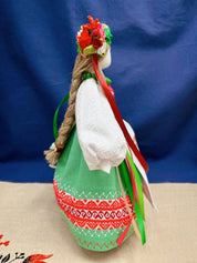 Handmade Ukrainian Motanka doll in traditional attire with floral crown and vibrant ribbons, symbolizing prosperity and protection.