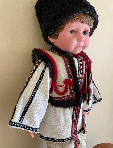 Handmade Ukrainian boy doll in traditional Carpathian outfit with black fur hat and embroidered details.