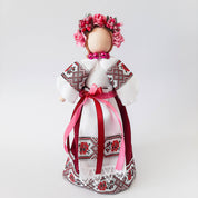 Ukrainian Motanka doll in traditional dress with floral headpiece and embroidered details, symbolizing cultural heritage.