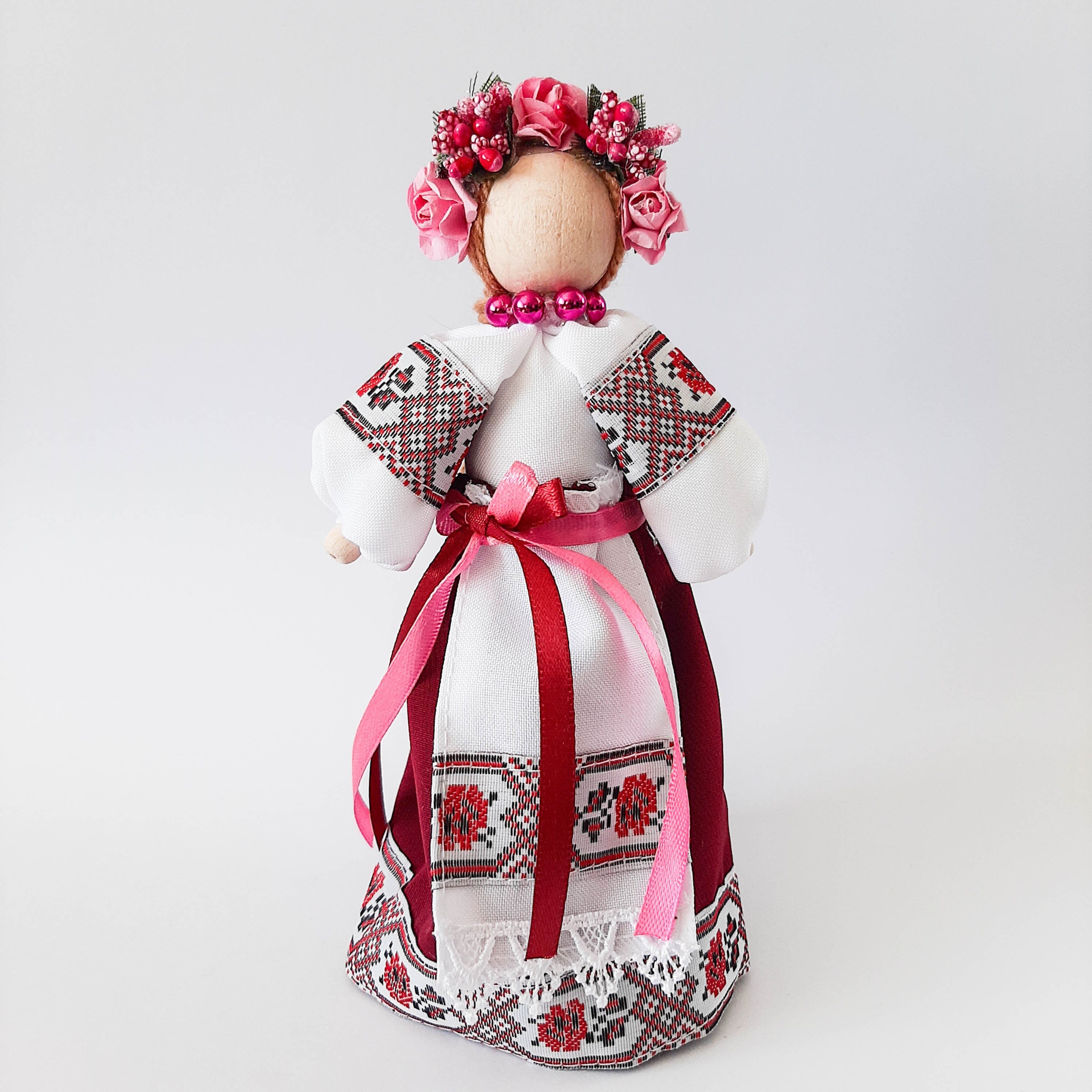 Ukrainian Motanka doll in traditional dress with floral headpiece and embroidered details, symbolizing cultural heritage.