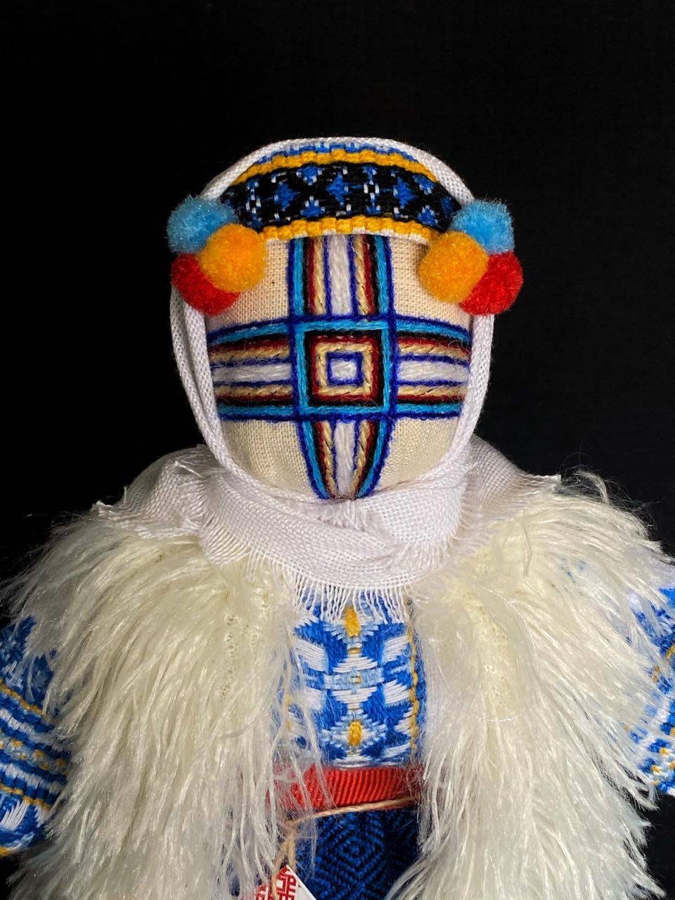 Handmade Ukrainian Motanka Doll 'Christmas' on a wooden stand, decorated with traditional festive attire and vibrant colors.