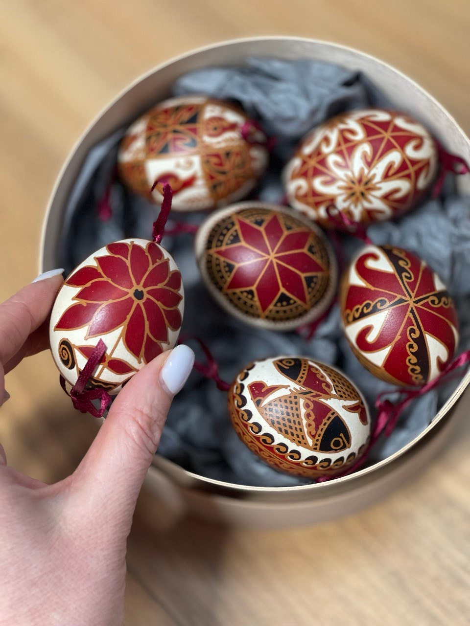 Set of 6 handmade Ukrainian Pysanky eggs in a box, showcasing intricate traditional folk art patterns and designs.