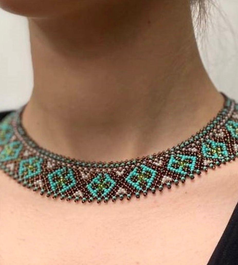 Handmade Ukrainian Sylyanka necklace with ceramic and turquoise beads, featuring ethnic geometric patterns, worn as an elegant choker.