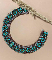 Handmade Ukrainian sylyanka necklace with ceramic and turquoise beads, featuring ethnic geometric and floral patterns on beige background.