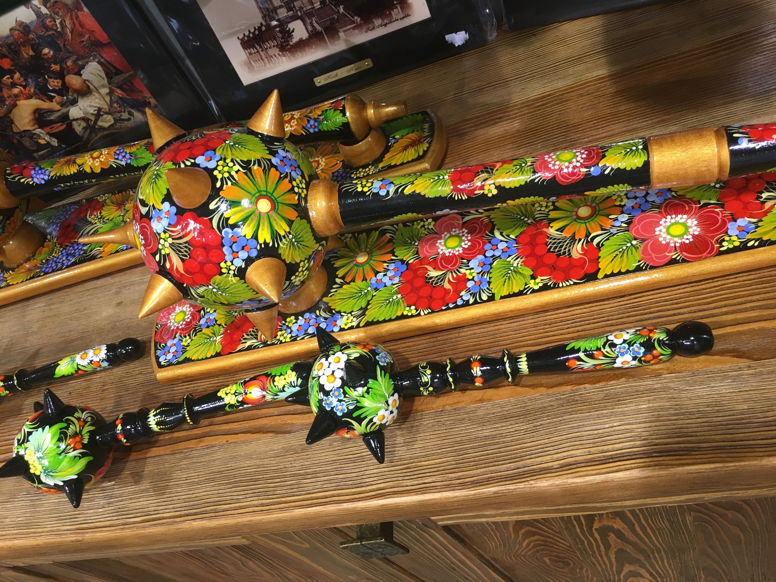 Handmade wooden Ukrainian Bulava maces with vibrant floral designs, showcasing traditional craftsmanship and national heritage.