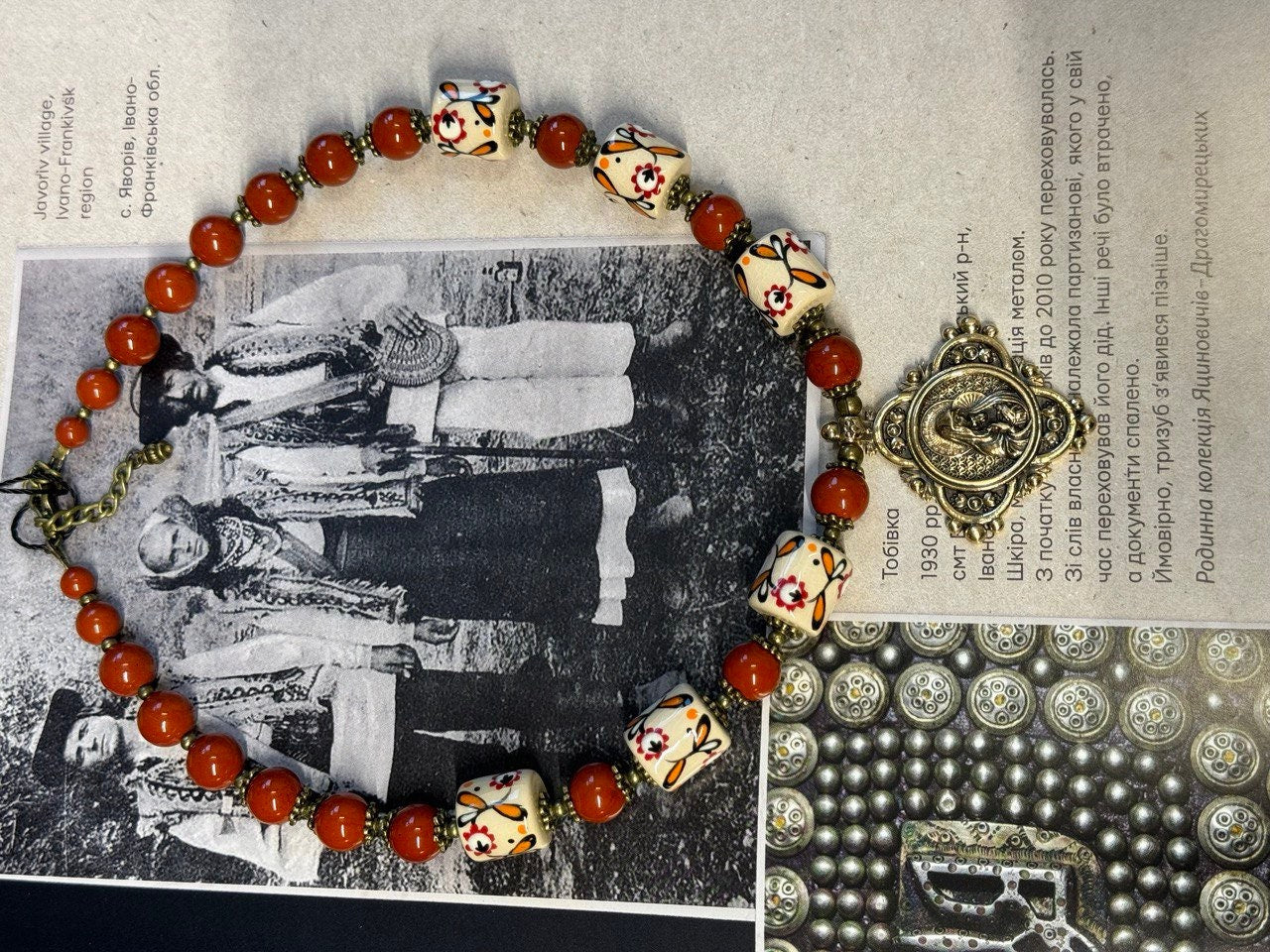 Ukrainian handmade necklace with white clay and jasper beads, displayed on traditional background, inspired by nature and culture.
