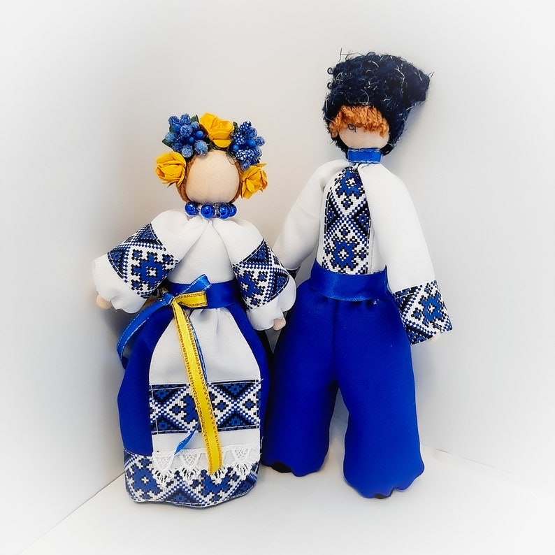 Handmade Ukrainian folk dolls in traditional clothing, featuring blue, yellow, red, and black embroidery designs.