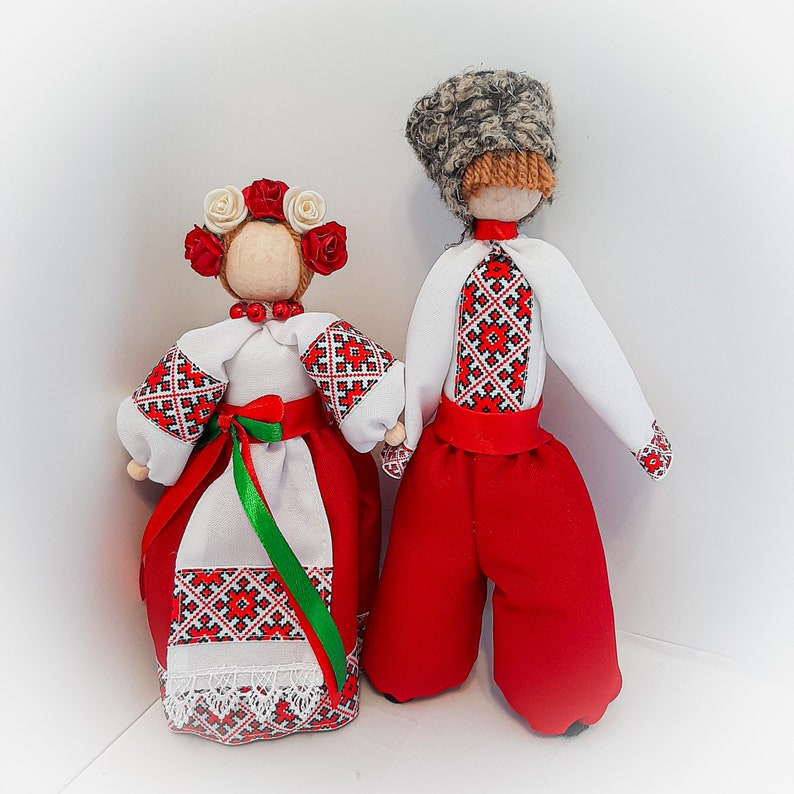 Handcrafted Ukrainian folk dolls in traditional embroidered clothing, showcasing cultural heritage with vibrant red and white designs.