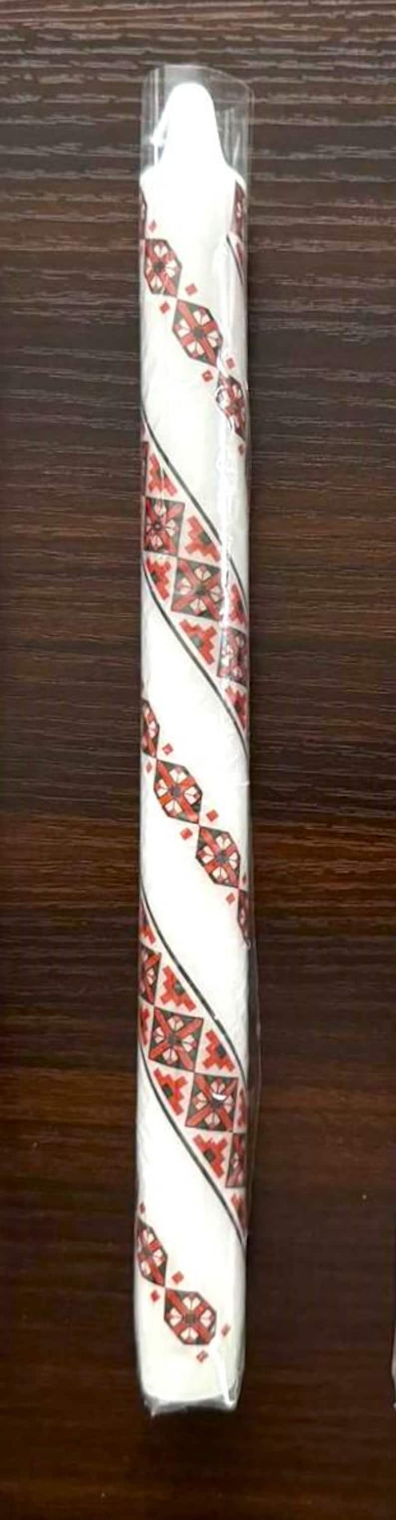 Handmade Ukrainian holiday taper candle with traditional red and white design, perfect for Christmas or Easter festive decor.