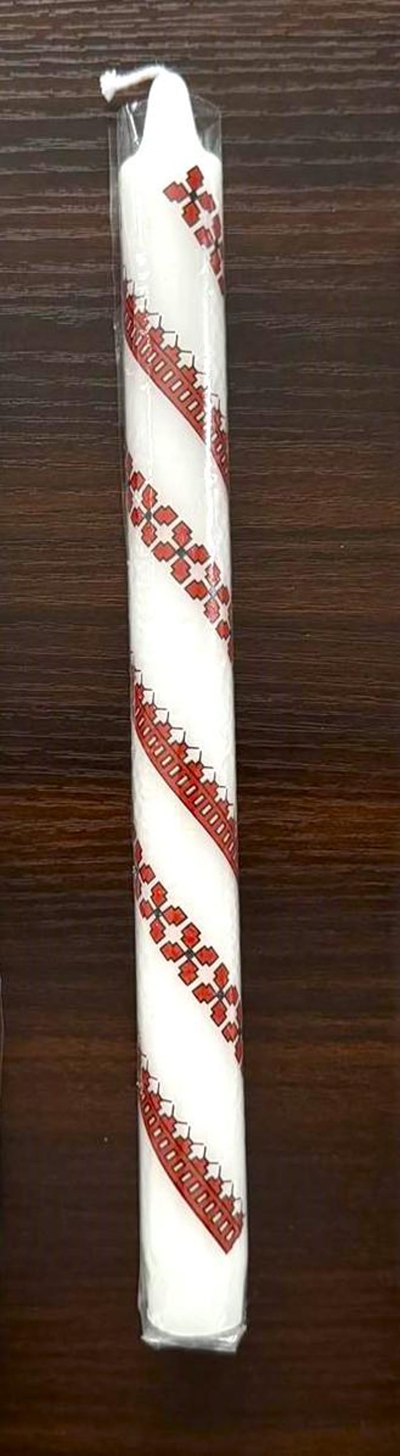 Handmade Ukrainian holiday taper candle with traditional red and white pattern, perfect for Christmas or Easter festive decor.