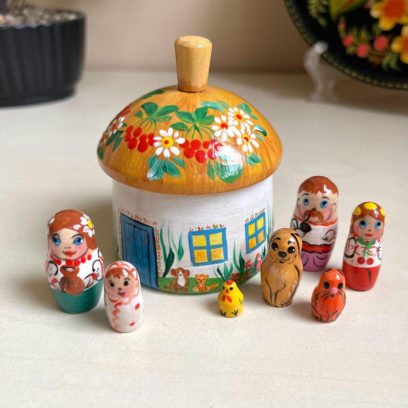 Hand-painted Ukrainian wooden house set with family dolls and animals, featuring ethnic decorations, ideal for kids' room decor.