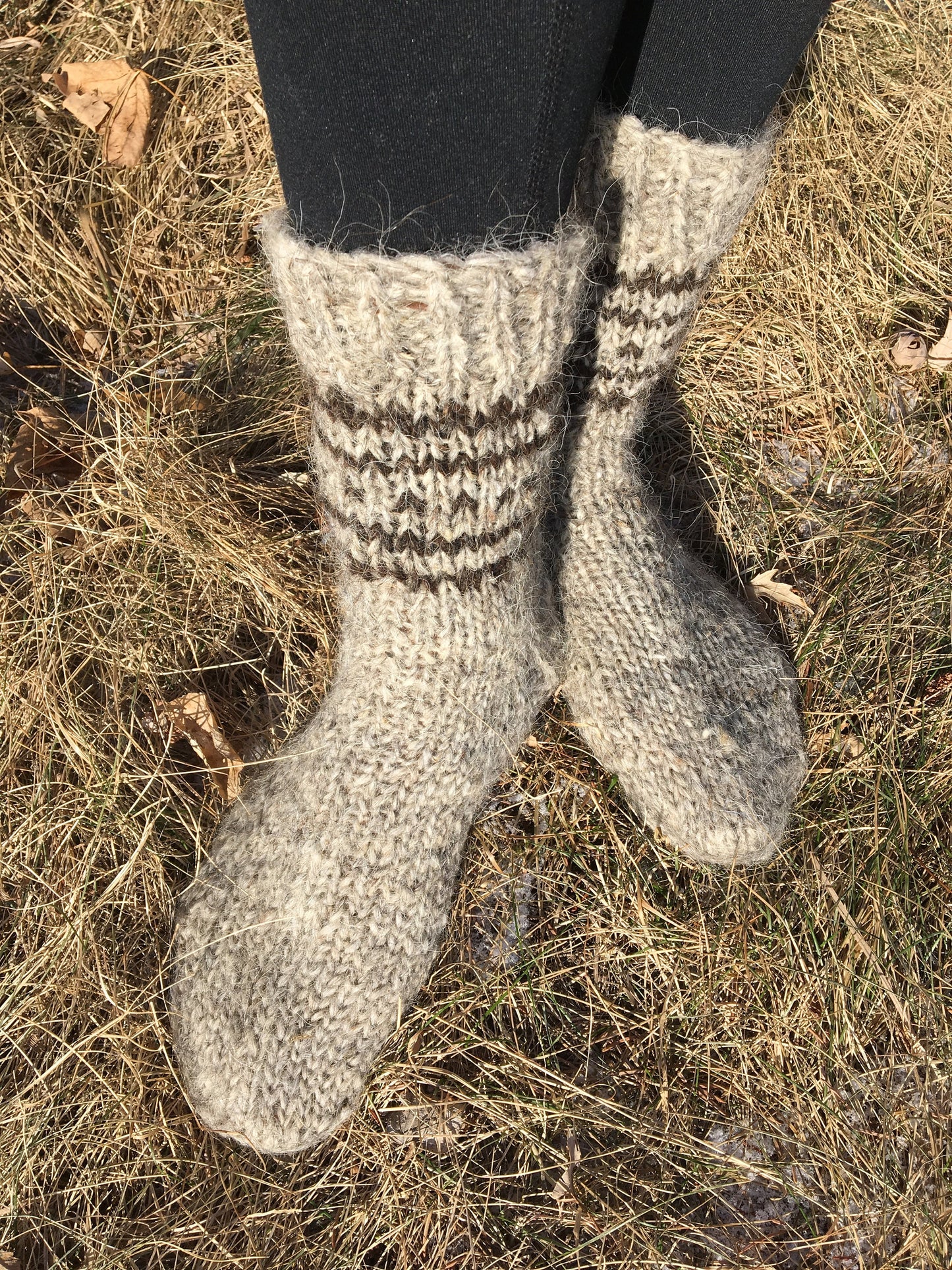 Hand-knitted unisex wool socks in natural setting, crafted from 100% organic sheep wool for warmth and comfort during winter.