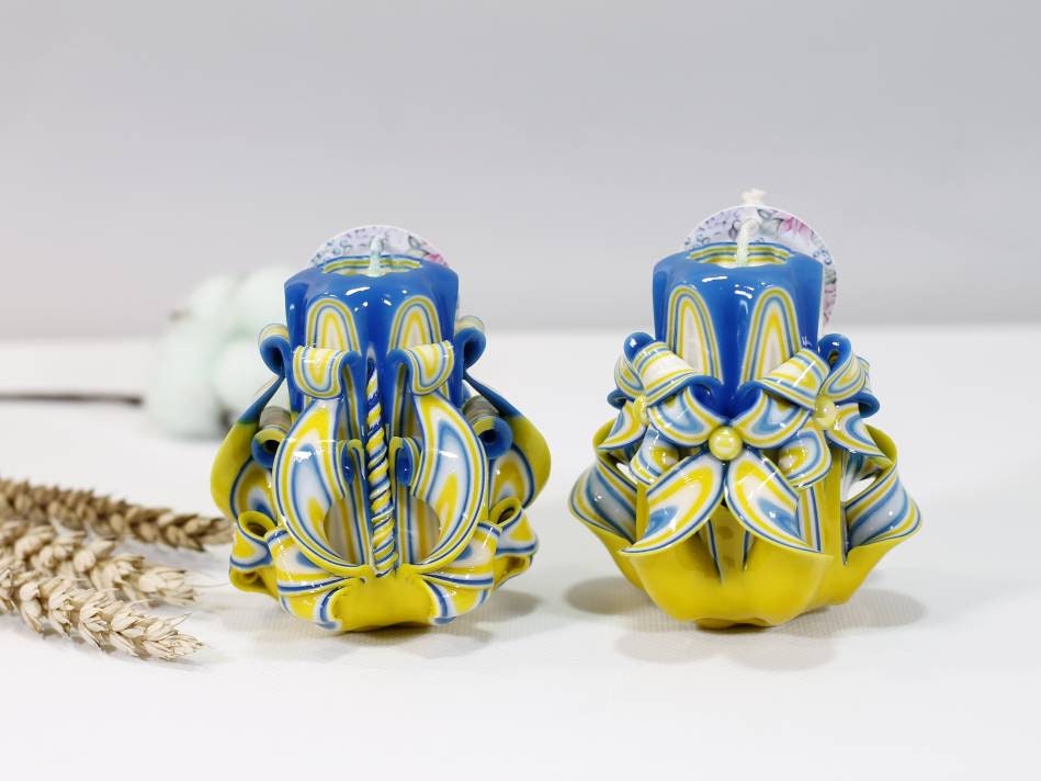 Handcrafted blue and yellow carved candle supporting Ukraine, symbolizing hope and unity. Proceeds aid Ukrainian families.