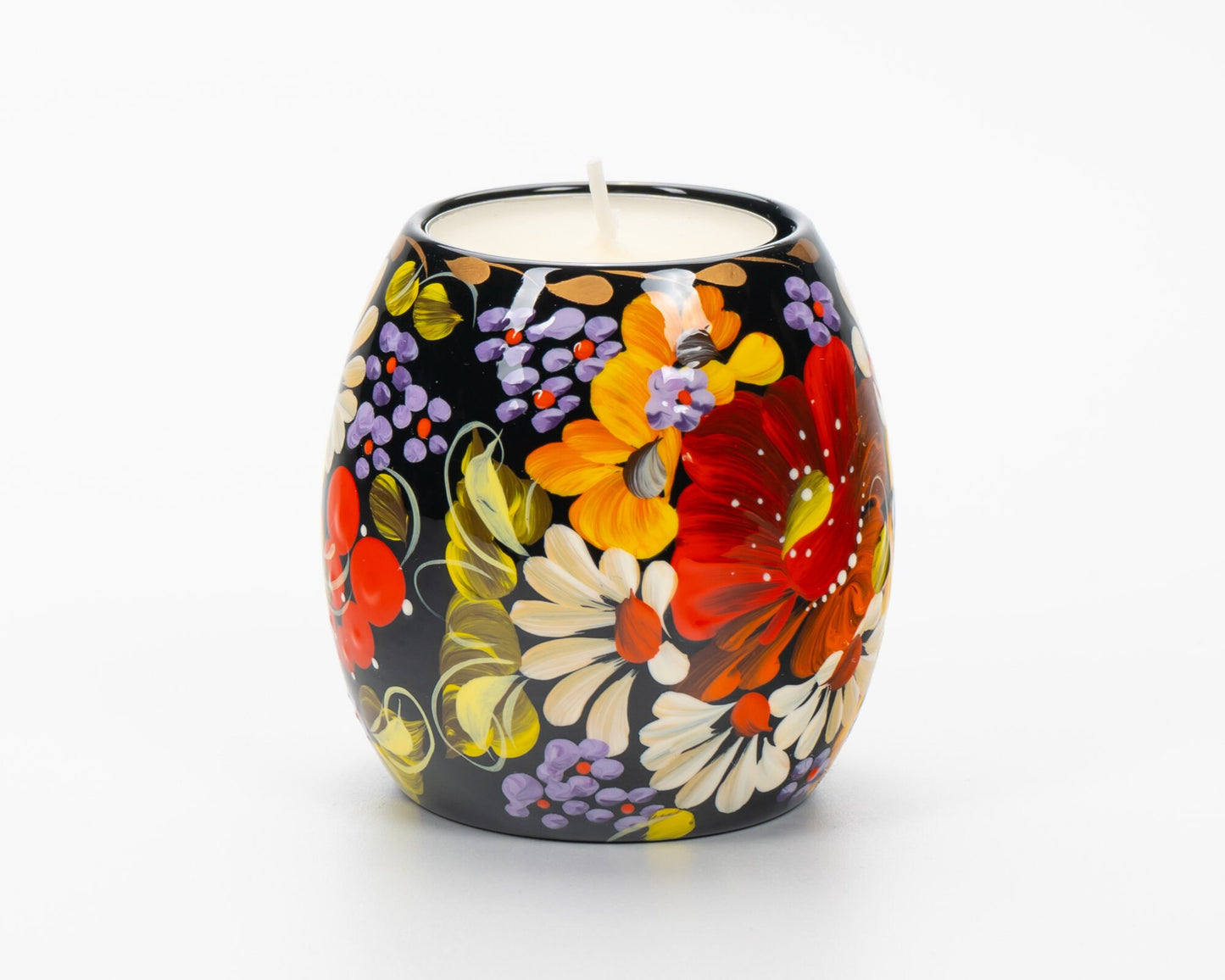 Hand-painted Ukrainian tea light candle holder with colorful Petrykivka floral design on a black background.