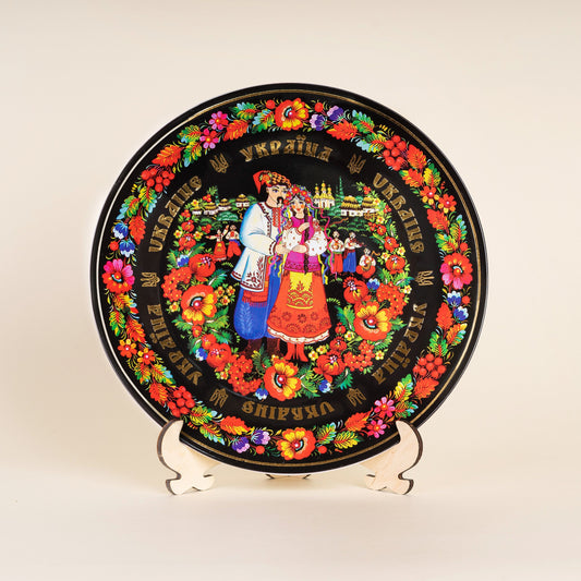 Ukrainian couple porcelain wall plate featuring vibrant Petrykivka painting, decorative cultural gift with wooden stand.