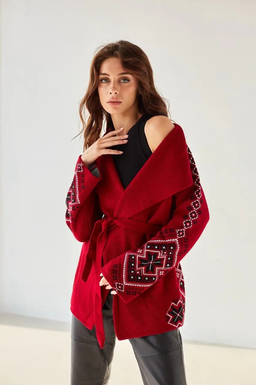 Women's boho knit cardigan with Ukrainian ornaments, oversized red wrap sweater, stylish winter fashion.