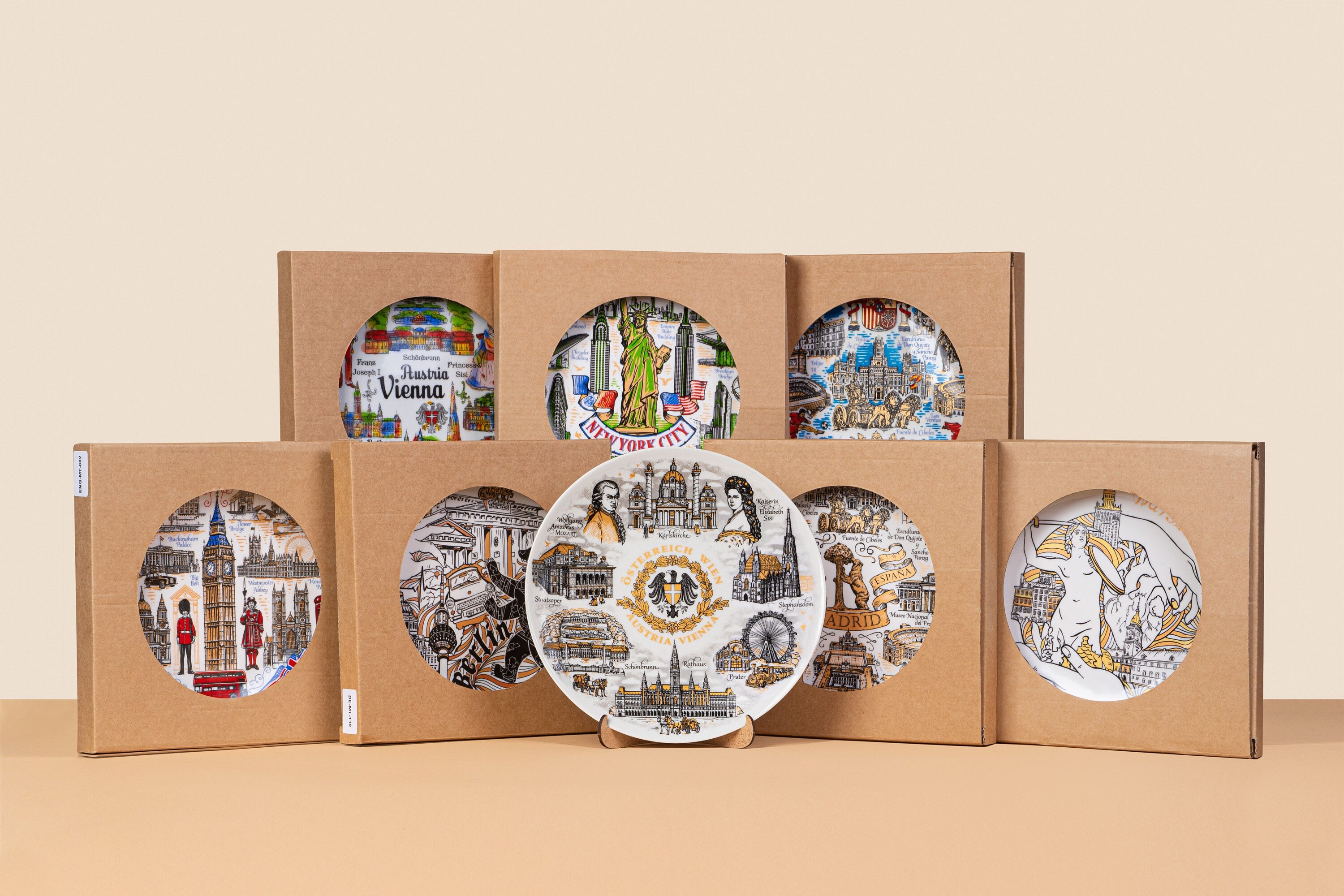 Collection of hand-painted souvenir plates featuring city landmarks, with a focus on a Ukrainian ceramic plate depicting Mykolaiv scenes.