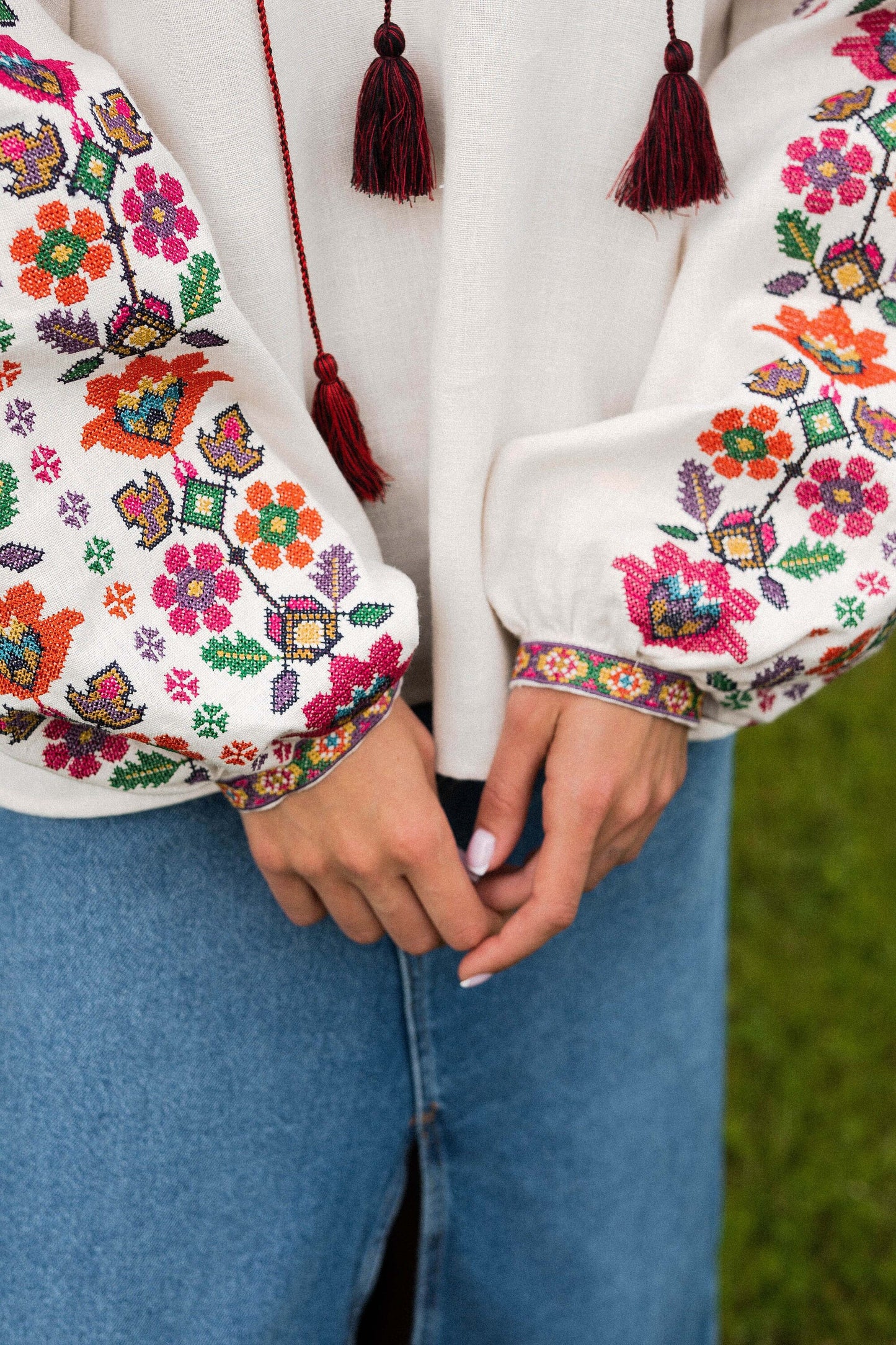 Linen Vyshyvanka blouse with floral Ukrainian embroidery on sleeves, paired with jeans.