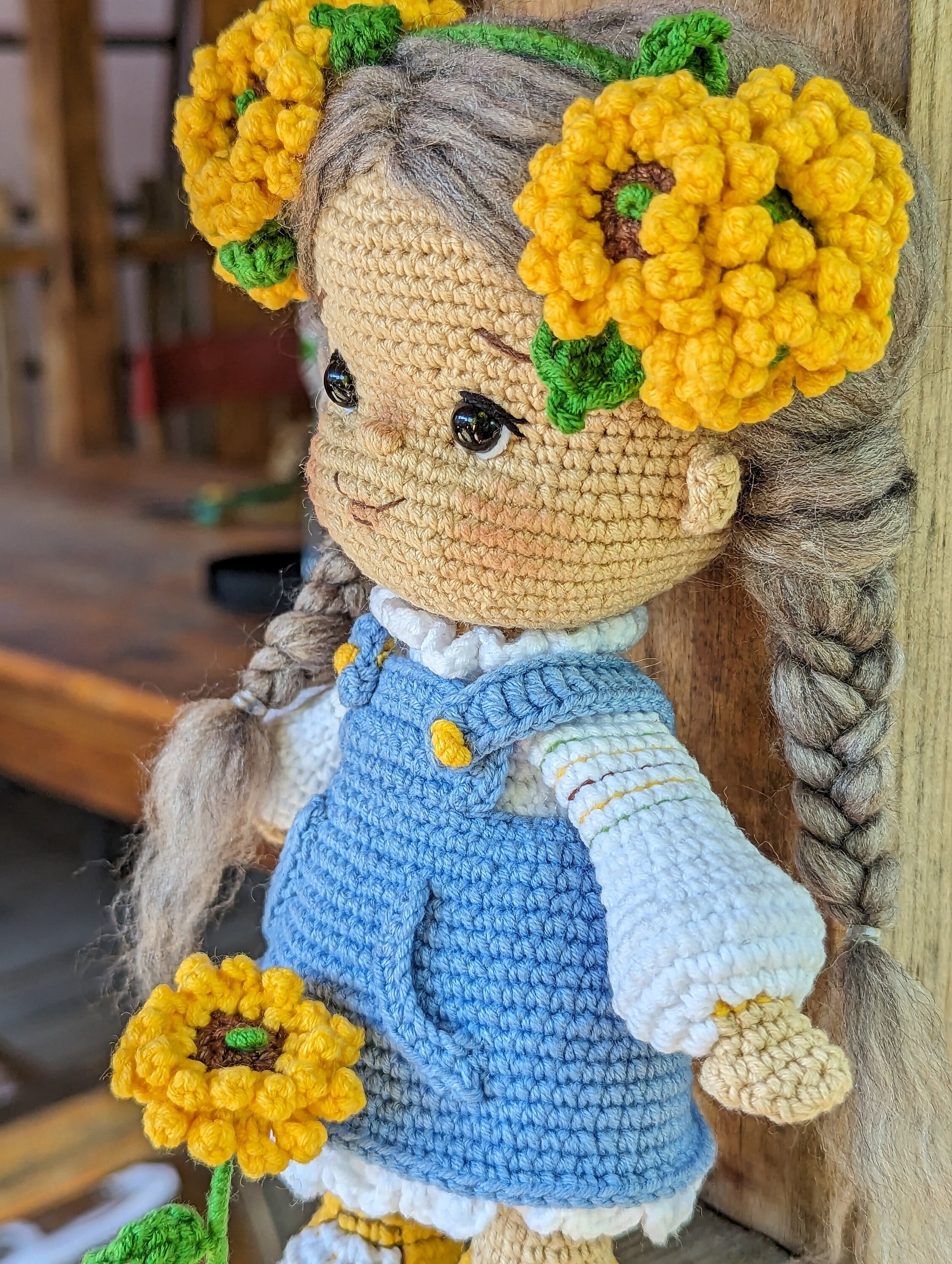 Handmade crochet Ukrainian doll with yellow flower adornments and blue dress, perfect cultural gift or nursery decor.