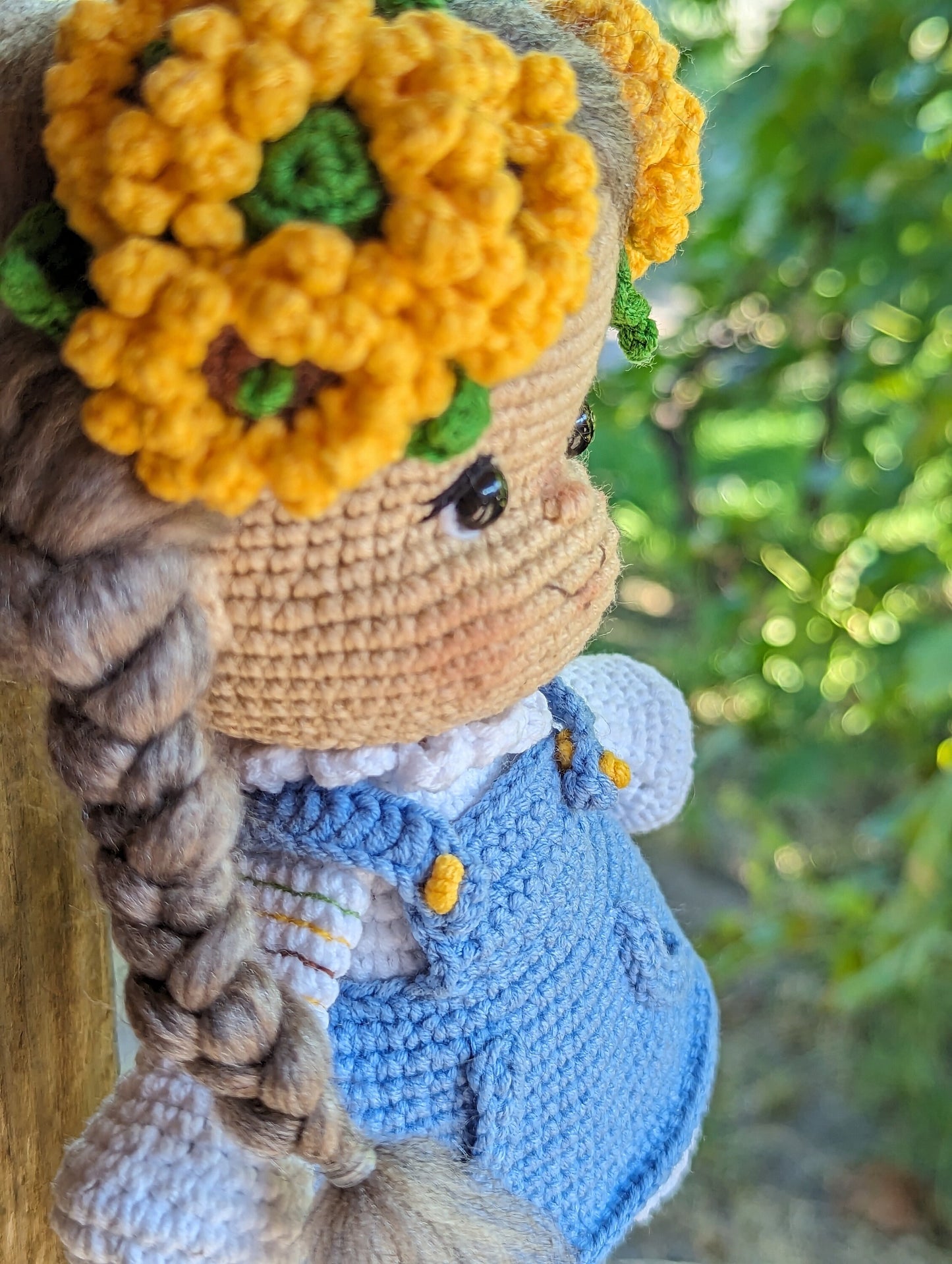 Handmade crochet Ukrainian doll in folk style with braided hair and floral headband, wearing a blue dress.