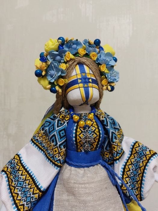 Handmade Ukrainian Motanka Doll with blue and yellow embroidery, floral headdress, symbolizing protection and Ukrainian heritage.