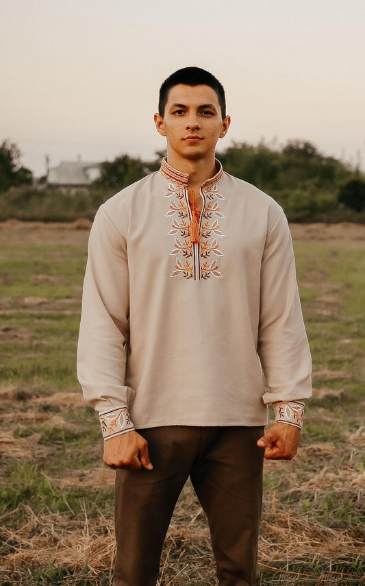 Man wearing embroidered Vyshyvanka shirt, Ukrainian traditional attire, standing outdoors, showcasing intricate cultural design.