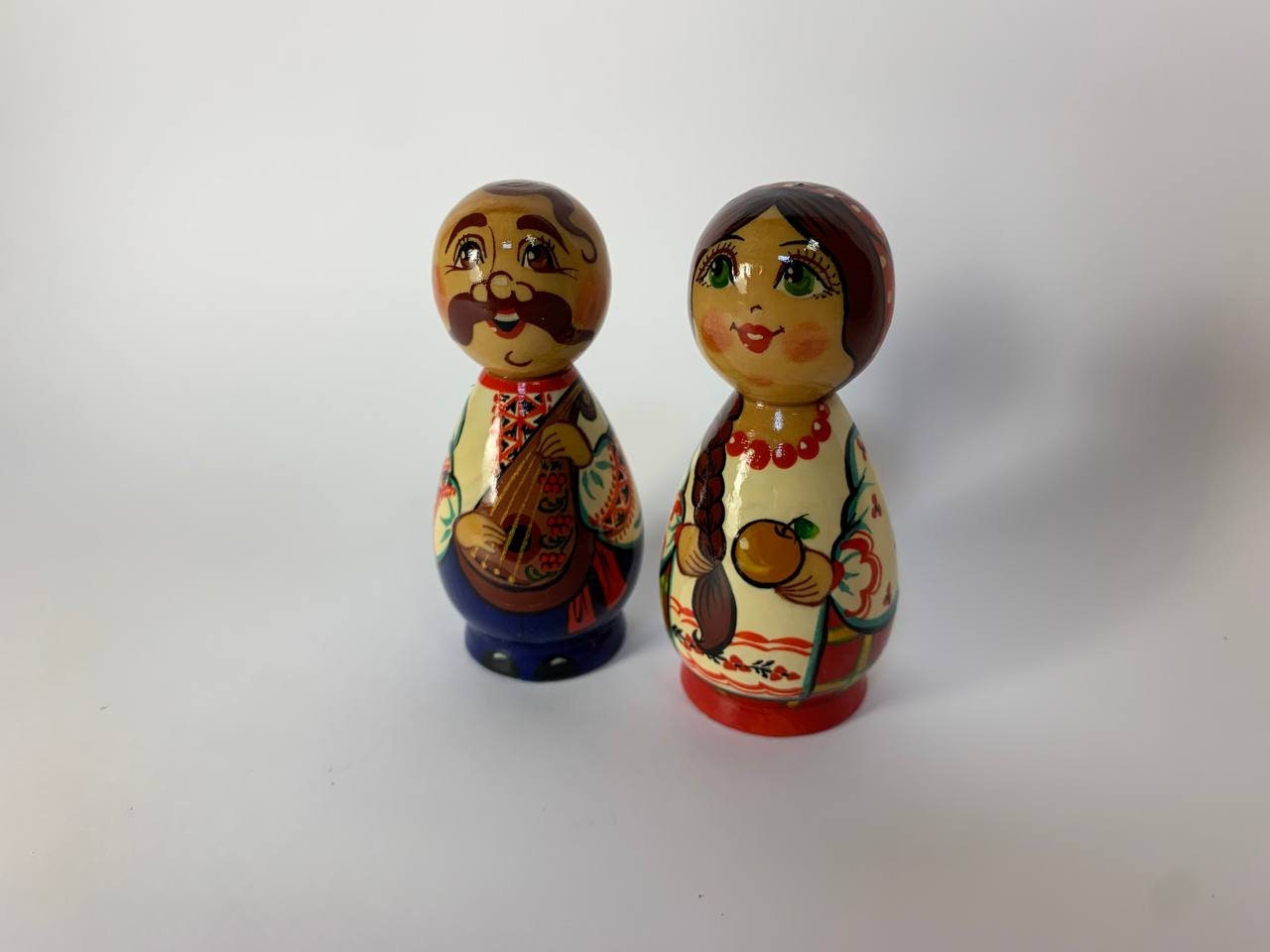 Hand-painted wooden figurines of Ukrainian Kozak and girl, showcasing traditional folk art, vibrant colors, and cultural heritage.