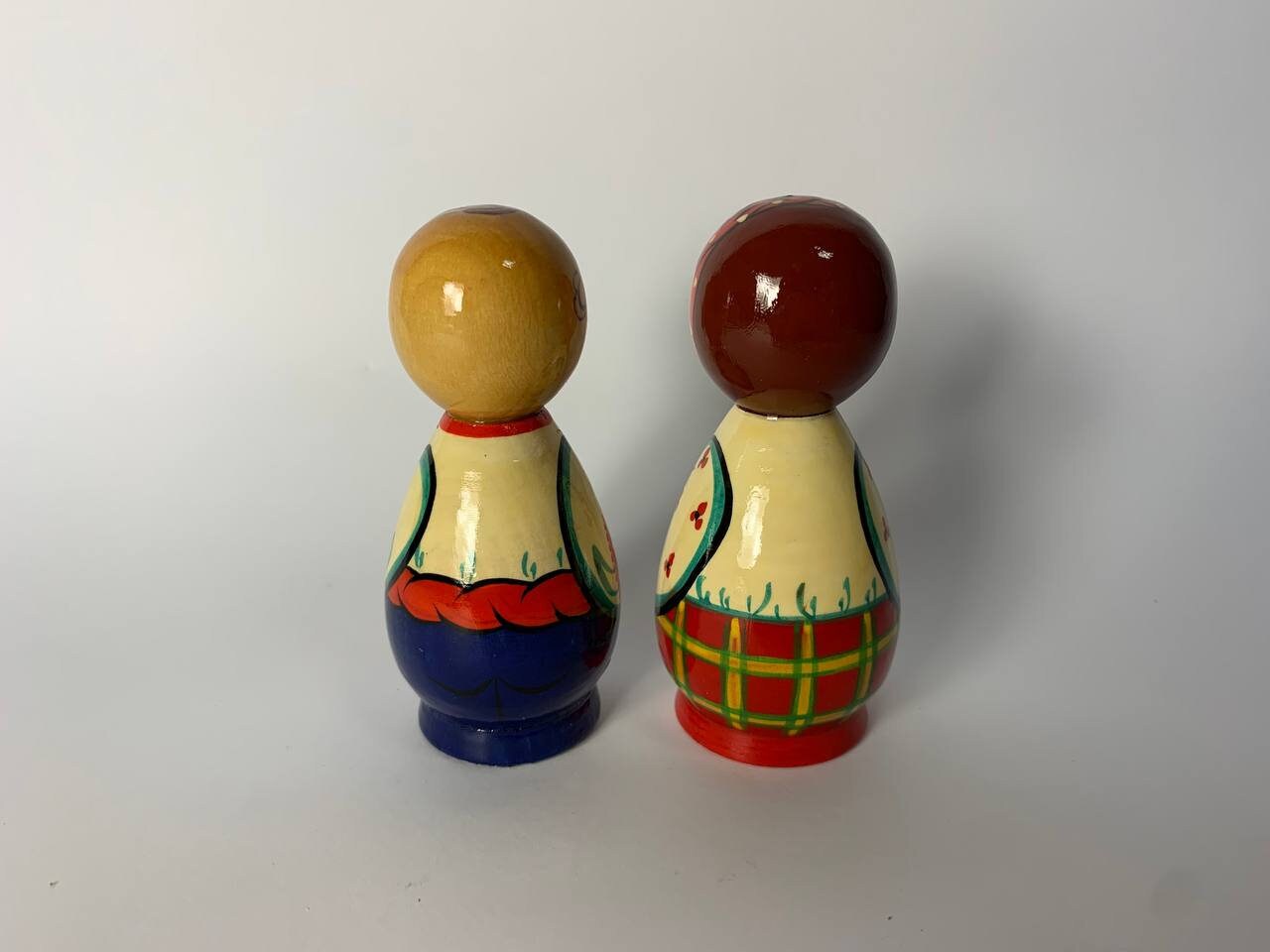 Hand-painted Ukrainian folk figurines, Kozak and girl, colorful wooden souvenirs, celebrate heritage and tradition with handmade artistry.