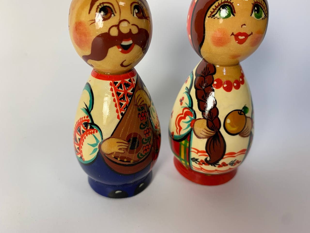 Hand-painted wooden figurines of Ukrainian folk couple, Kozak and girl, showcasing vibrant traditional designs.