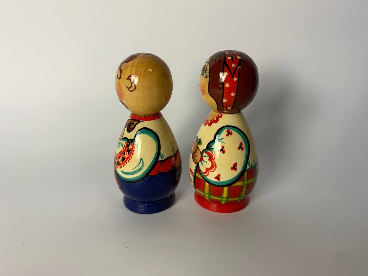 Hand-painted wooden figurines of a Ukrainian Kozak and girl, showcasing vibrant traditional folk art and cultural heritage.