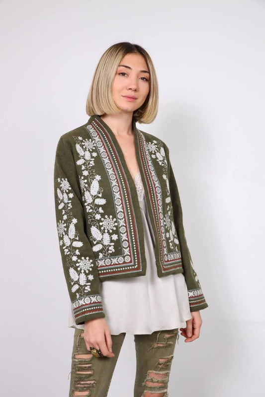 Woman wearing khaki embroidered Vyshyvanka jacket with Ukrainian ornament, showcasing cultural elegance and style.