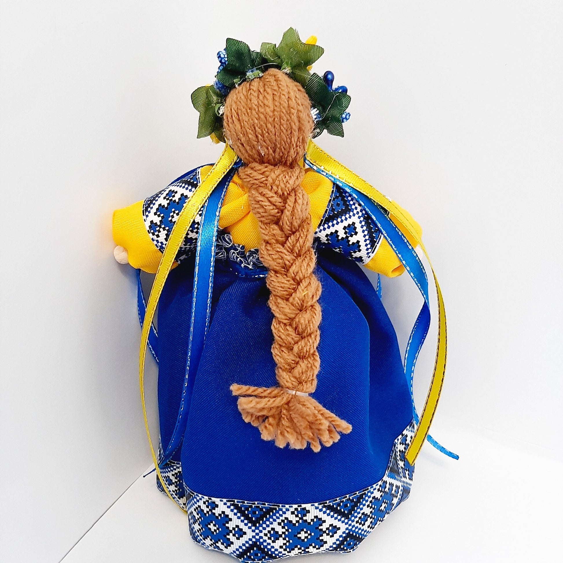 Ukrainian Motanka Doll Amulet with blue embroidered dress and braided hair, symbolizing home and family protection.