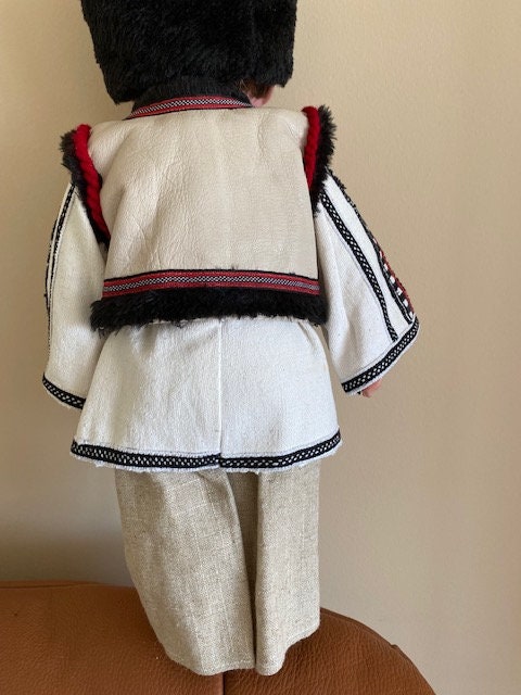 Handmade Ukrainian boy doll in traditional Carpathian outfit with embroidered details and fur headpiece.