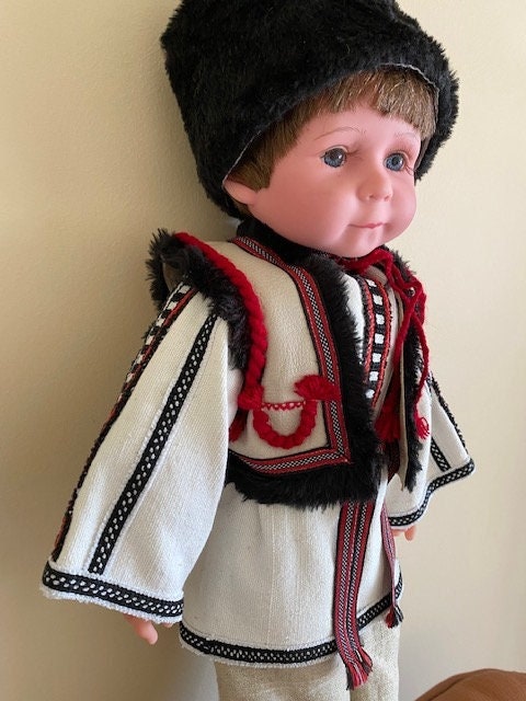 Handmade Ukrainian boy doll in traditional Carpathian outfit with black fur hat and embroidered details.