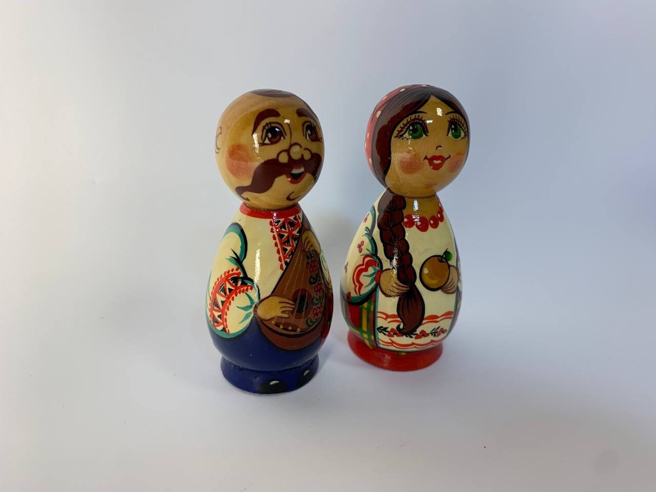 Hand-painted wooden figurines of a Ukrainian girl and Kozak in traditional attire, cultural souvenir gift.